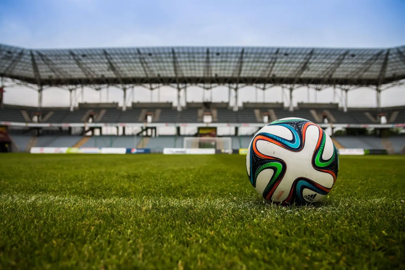 Ballon de football posé sur la pelouse d'un stade vide, photo d'illustration