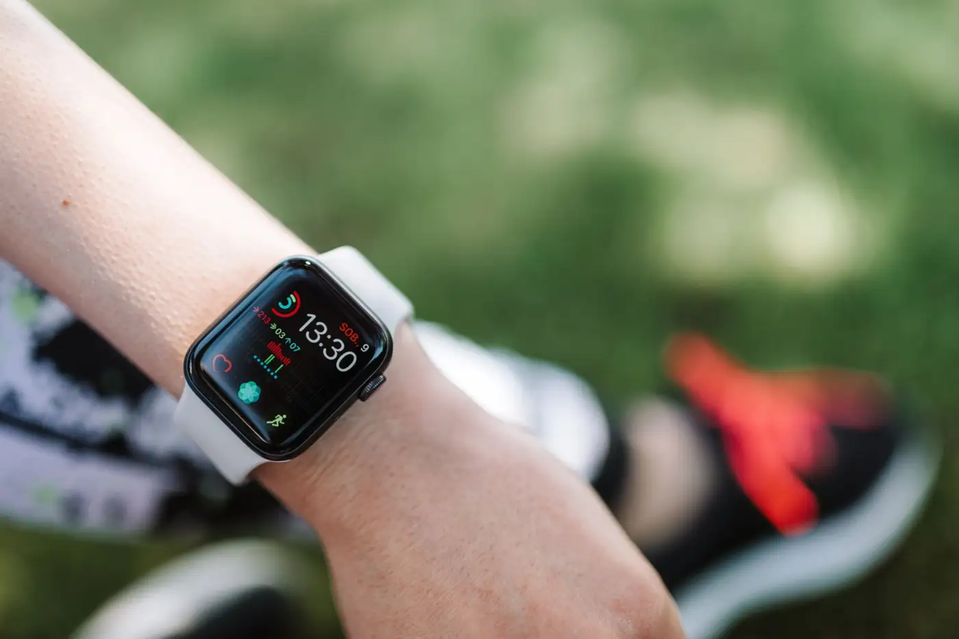 Gros plan sur une montre connectée au poignet d'une personne en tenue de sport, écran affichant l'heure et des indicateurs d'activité