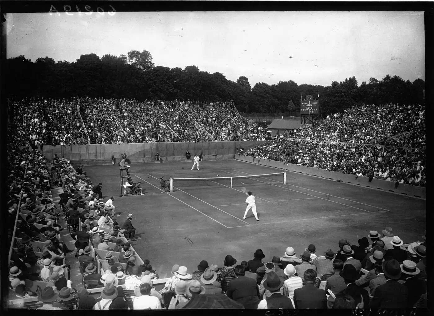 Vue générale du stade Roland-Garros en 1928 pendant une rencontre de Coupe Davis, tribunes pleines de spectateurs en chapeaux